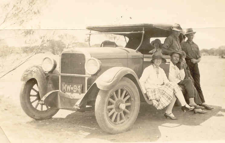 Irene and Don seated on running board, Don Jnr leaning back against car. Is that Helen in the back seat ?